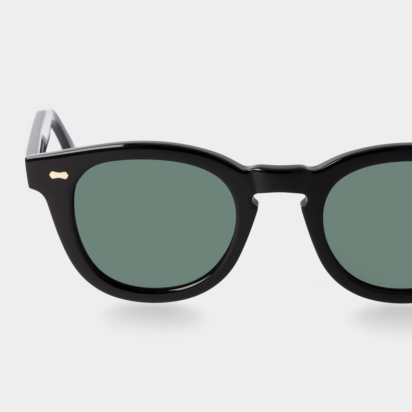 Black sunglasses with green lenses on a white background. - DEI DUCHI