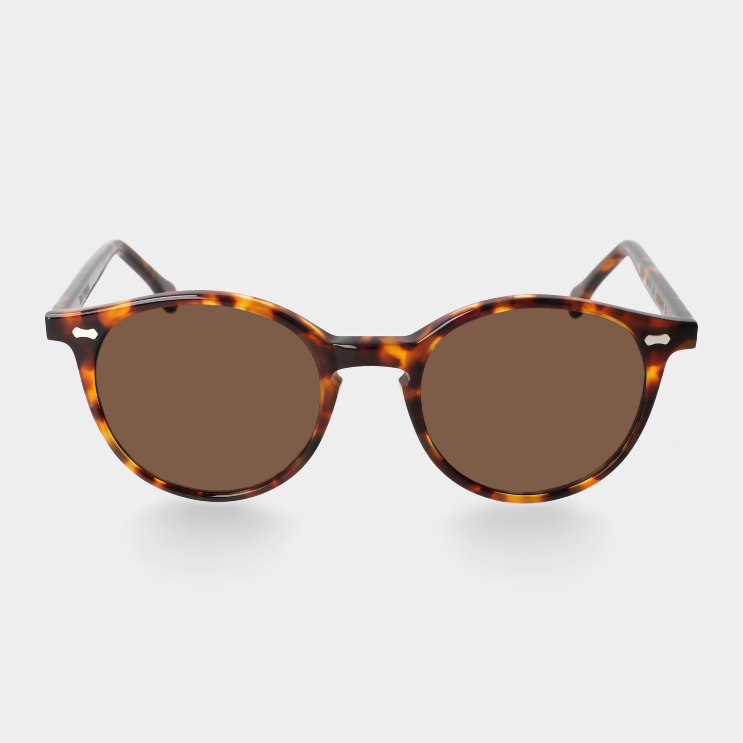Sunglasses with tortoiseshell frame and brown lenses on a light gray background. - DEI DUCHI