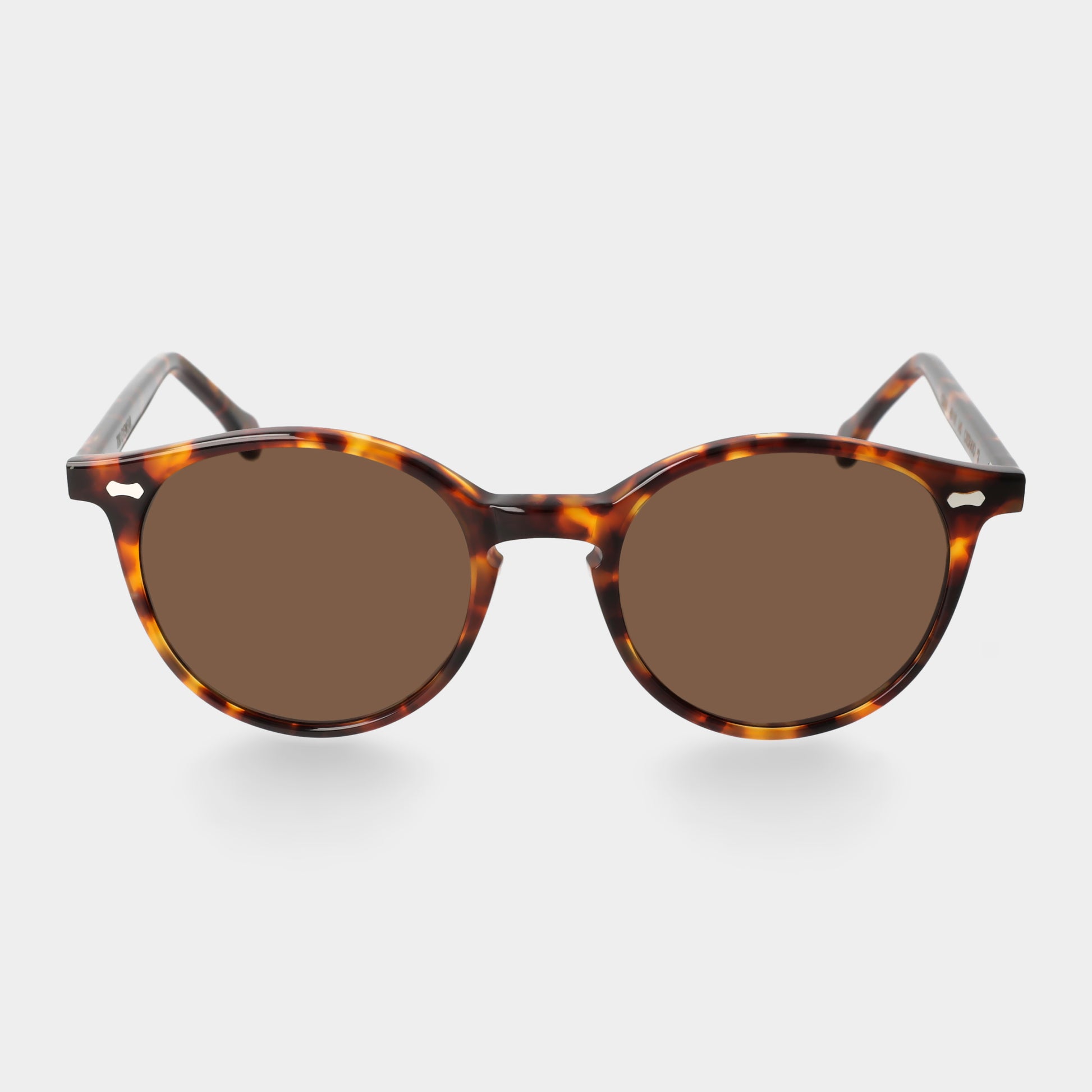 Sunglasses with tortoiseshell frame and brown lenses on a light gray background. - DEI DUCHI