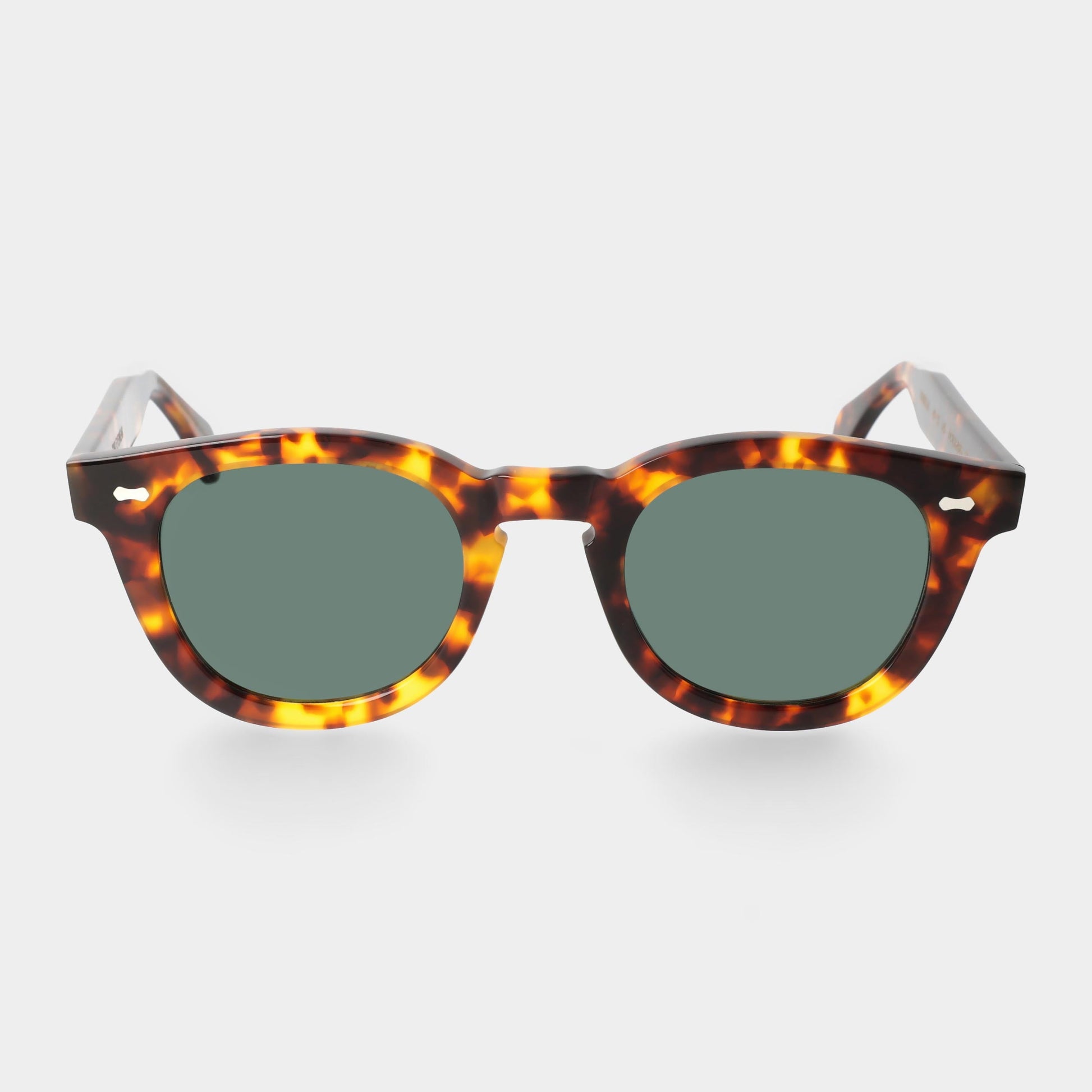 Sunglasses with tortoiseshell frame and green lenses on a white background. - DEI DUCHI