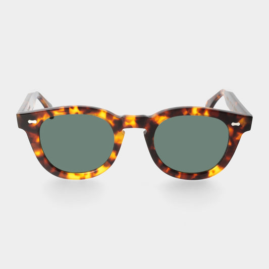 Sunglasses with tortoiseshell frame and green lenses on a white background. - DEI DUCHI