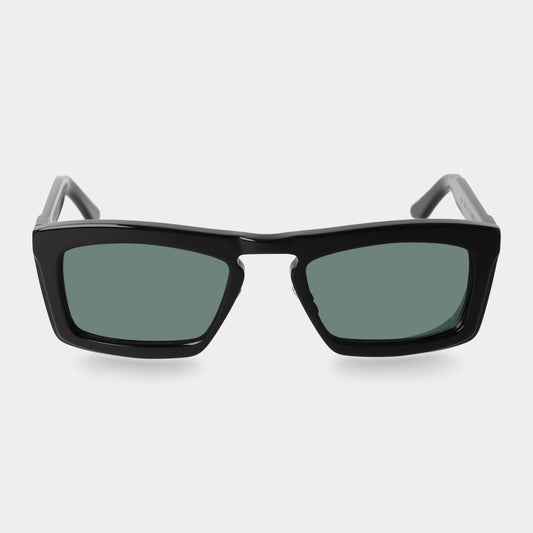 Black sunglasses with green lenses on a light gray background. - Dei Duchi