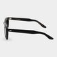 Black sunglasses with green lenses on a light gray background. - Dei Duchi