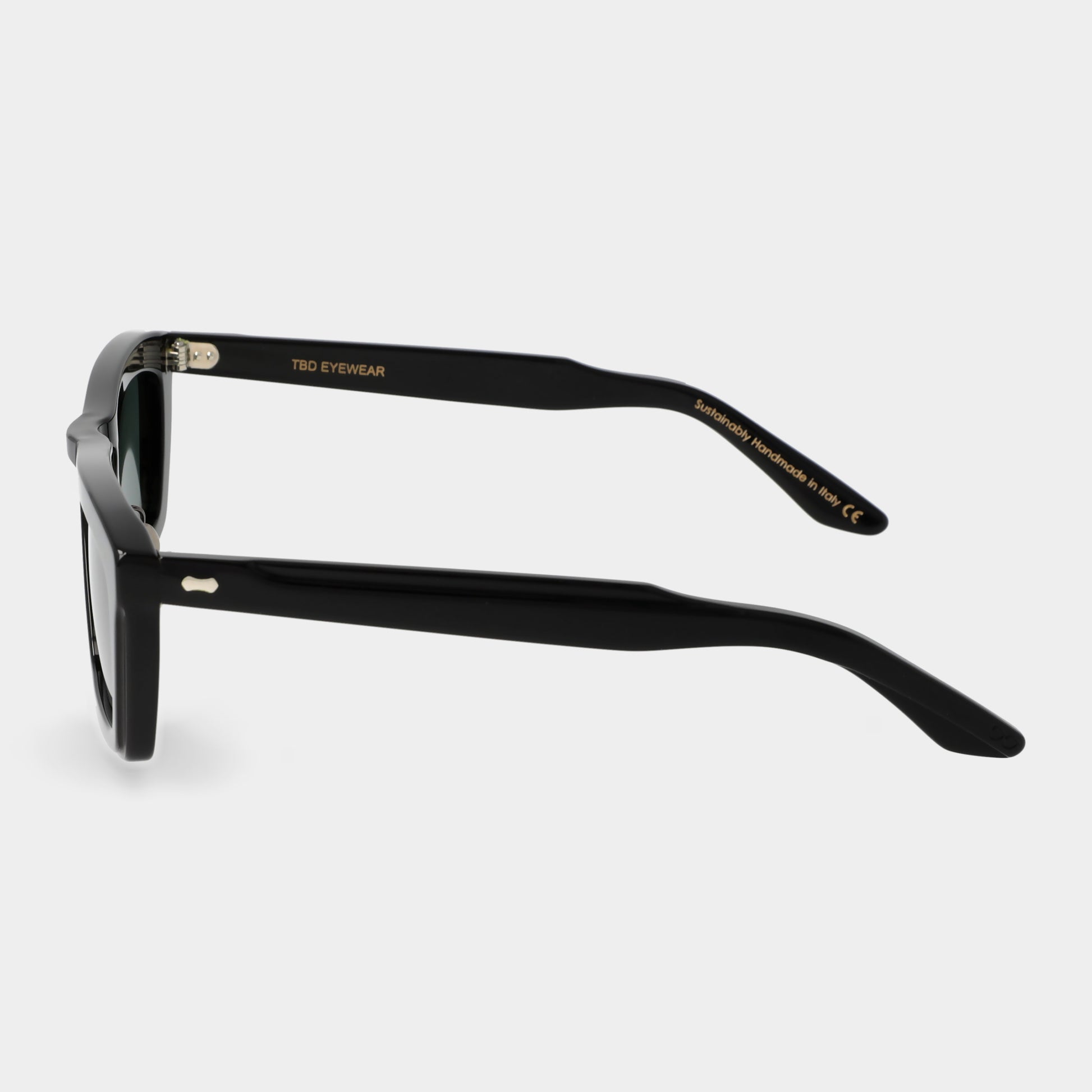 Black sunglasses with green lenses on a light gray background. - Dei Duchi