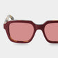 Sunglasses with red-tinted lenses on a light gray background. - Dei Duchi