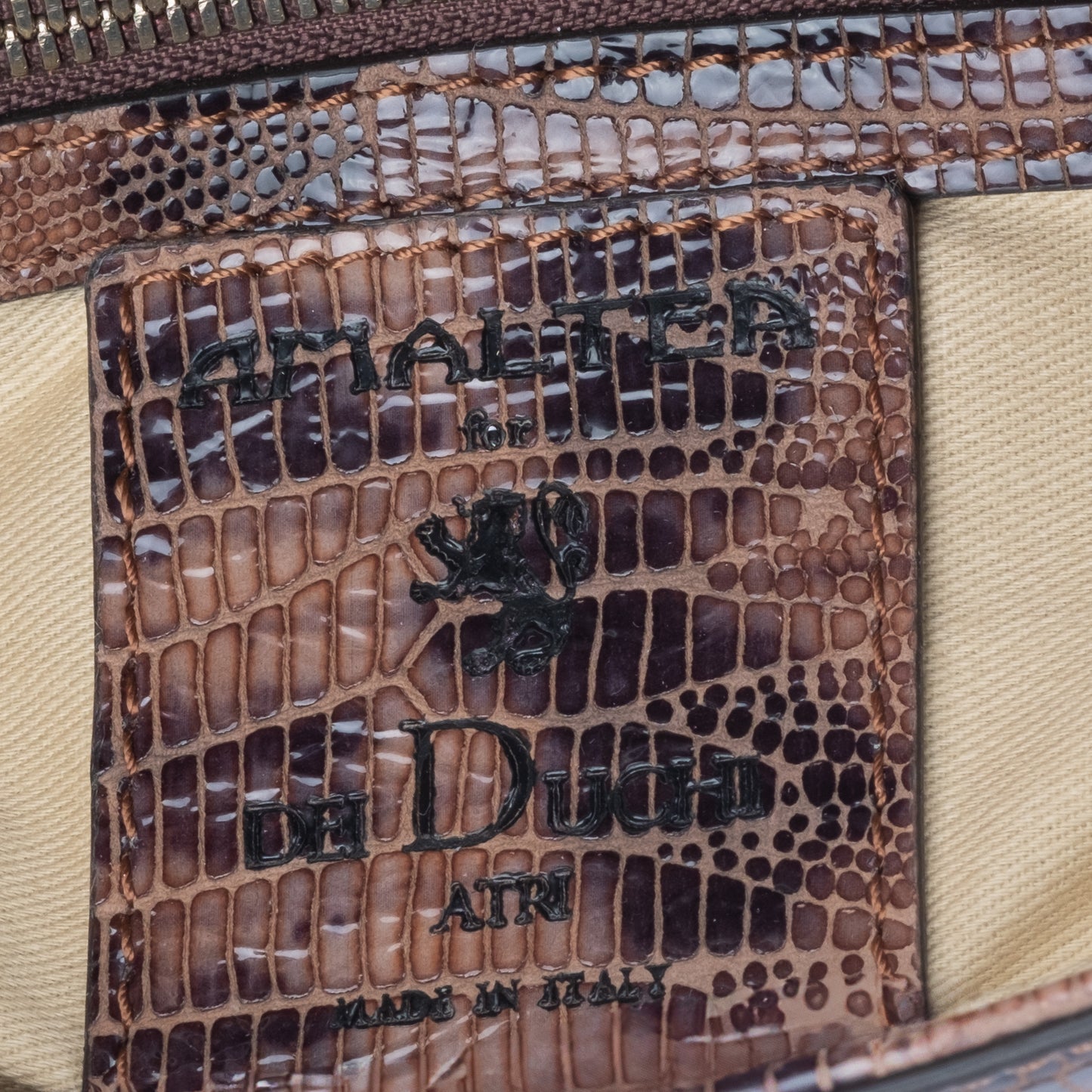 Brown leather  textured handbag brand tag AMALTEA for DEI DUCHI, on a white background. - DEI DUCHI (AMALTEA)