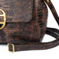 Brown leather textured handbag with a gold clasp on a white background. DEI DUCHI (AMALTEA)