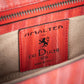 Close-up of a red leather label with 'Amaltea for Dei Duchi' branding on a leather bag product. - DEI DUCHI (AMALTEA)