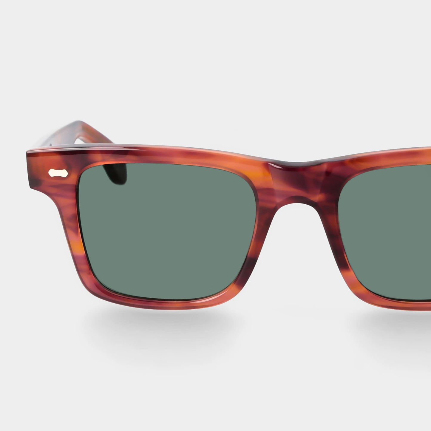 Sunglasses with tortoiseshell frame and green lenses on a light gray background. - DEI DUCHI