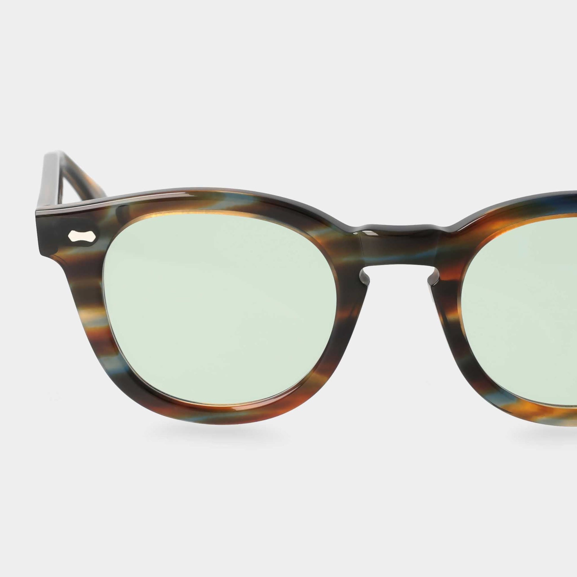Sunglasses with tortoiseshell frame and green lenses on a white background. - DEI DUCHI