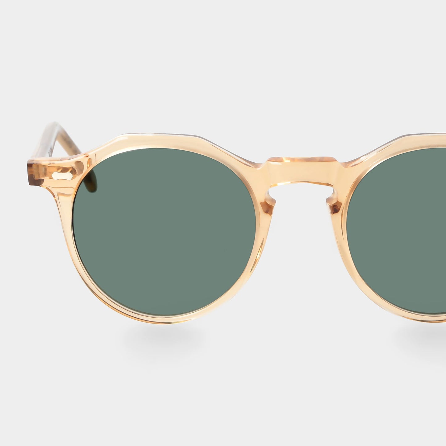 Gold-framed sunglasses with green lenses on a light gray background. - DEI DUCHI