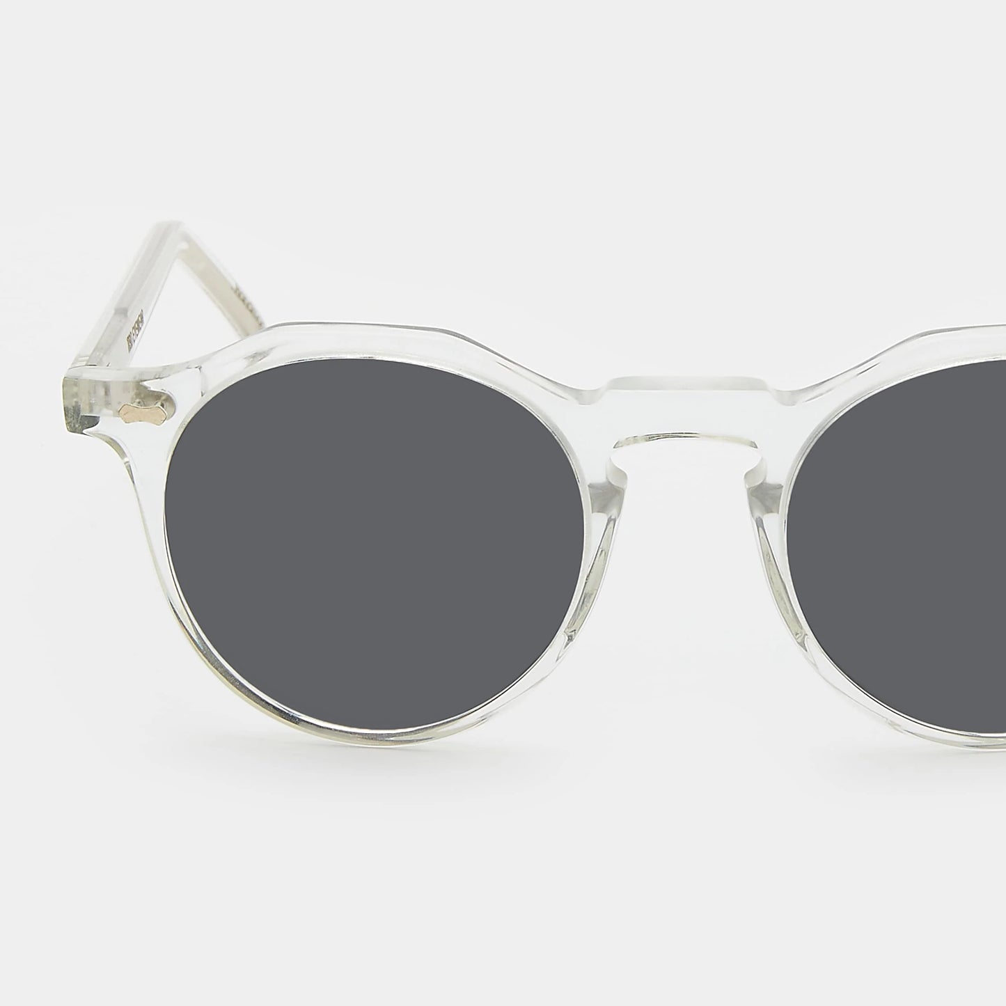 Round sunglasses with clear frame and grey lenses on a white background. - DEI DUCHI