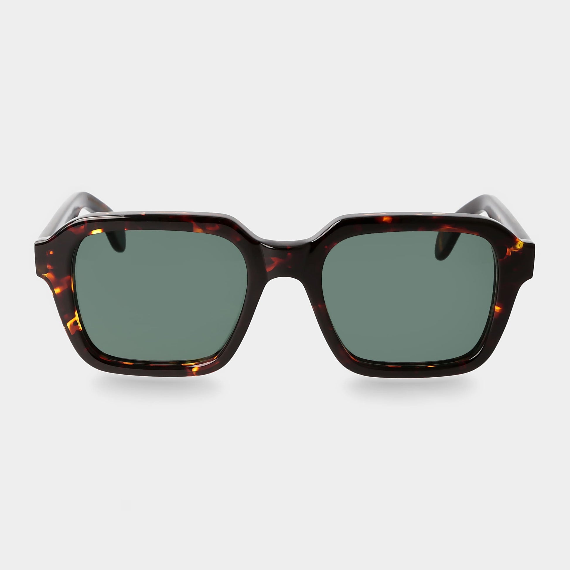 Sunglasses with tortoiseshell frame and green lenses on a light gray background. _ DEI DUCHI