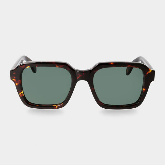 Sunglasses with tortoiseshell frame and green lenses on a light gray background. _ DEI DUCHI
