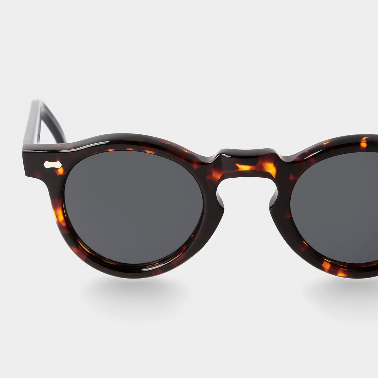 Round sunglasses with tortoiseshell frame on a light gray background. - Dei Duchi