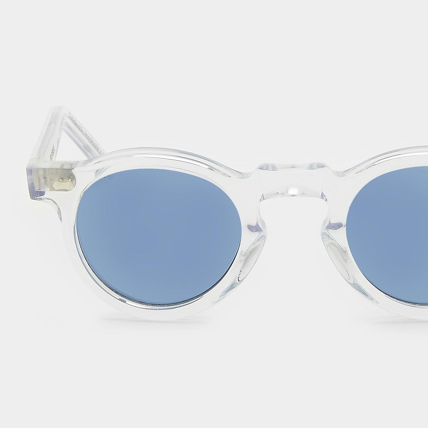 Clear frame sunglasses with blue lenses on a white background. - DEI DUCHI